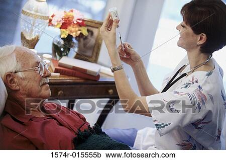 Stock Image - High angle view of a female nurse filling an injection. Fotosearch