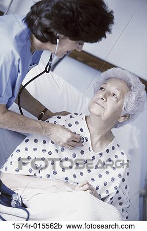 High angle view of a female nurse examining a senior woman View Large Photo Image Stock Image - High angle view of a female nurse examining a senior woman. Fotosearch