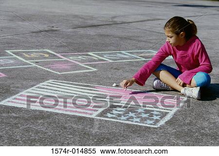 Stock Photography - High angle view of a girl drawing an American flag on the ground with chalk. Fotosearch