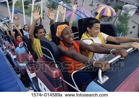 Stock Image - High angle view of a group of teenagers riding a rollercoaster. Fotosearch