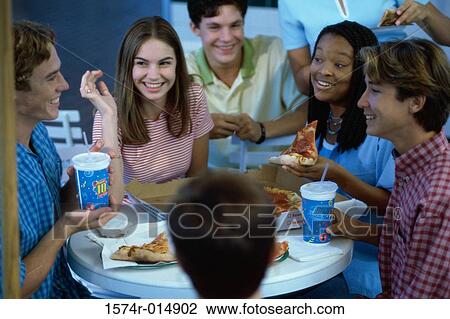 High angle view of a group of teenagers eating pizza in a restaurant View Large Photo Image Stock Image - High angle view of a group of teenagers eating pizza in a restaurant. Fotosearch