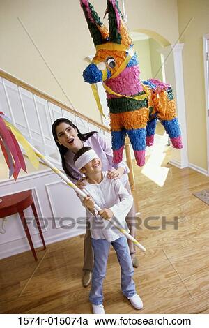 High angle view of a mother helping her daughter hit a pinata View Large Photo Image Stock Image - High angle view of a mother helping her daughter hit a pinata. Fotosearch