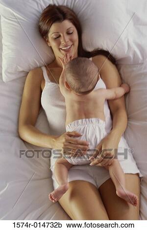 High angle view of a mother lying with her baby boy View Large Photo Image Stock Image - High angle view of a mother lying with her baby boy. Fotosearch
