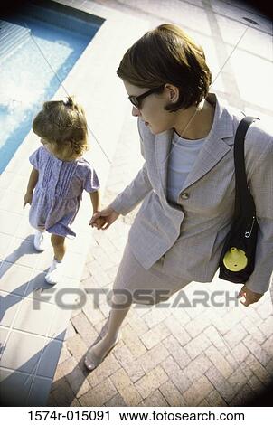 Stock Image - High angle view of a mother walking with her daughter. Fotosearch