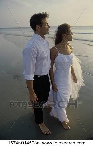 High angle view of a newlywed couple walking on the beach View Large Photo Image Stock Image - High angle view of a newlywed couple walking on the beach. Fotosearch
