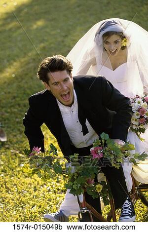 High angle view of a newlywed couple riding a bicycle View Large Photo Image Stock Image - High angle view of a newlywed couple riding a bicycle. Fotosearch