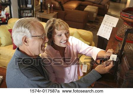 High angle view of a senior couple looking at a price tag in a furniture store View Large Photo Image Stock Image - High angle view of a senior couple looking at a price tag in a furniture store. Fotosearch
