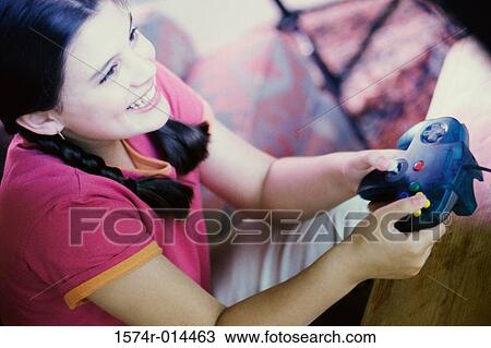 High angle view of a teenage girl playing video games View Large Photo Image Stock Image - High angle view of a teenage girl playing video games. Fotosearch