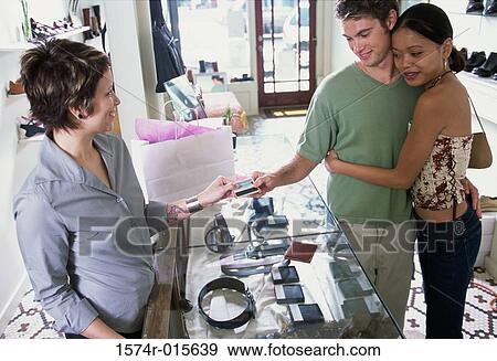Stock Photo - High angle view of a young couple standing at a checkout counter. Fotosearch