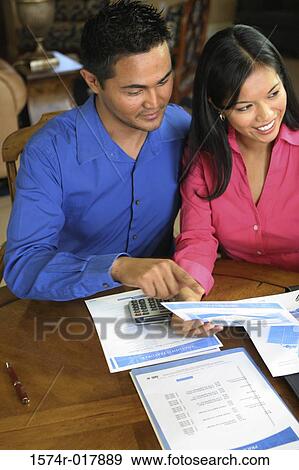 High angle view of a young couple reading a bill View Large Photo Image Stock Photo - High angle view of a young couple reading a bill. Fotosearch
