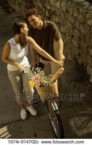 Stock Image - High angle view of a young couple with a bicycle. Fotosearch