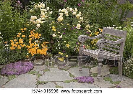 Stock Photograph - High angle view of an armchair and flowers in a garden. Fotosearch