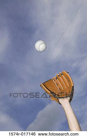 Low angle view of a baseball player catching a ball View Large Photo Image Stock Photograph - Low angle view of a baseball player catching a ball. Fotosearch