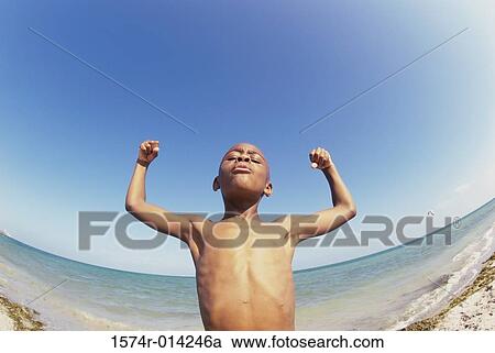 Low angle view of a boy flexing his muscles on the beach View Large Photo Image Stock Image - Low angle view of a boy flexing his muscles on the beach. Fotosearch