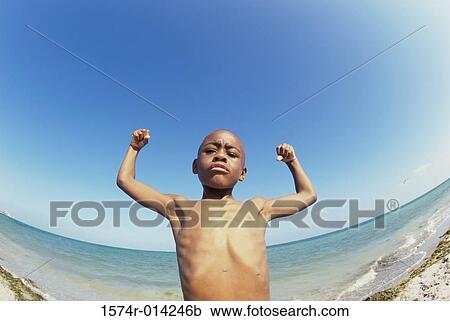 Low angle view of a boy flexing his muscles on the beach View Large Photo Image Stock Image - Low angle view of a boy flexing his muscles on the beach. Fotosearch