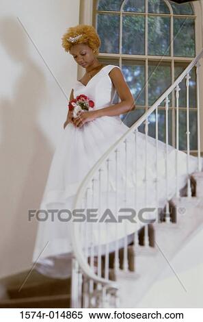 Low angle view of a bride holding a bouquet of flowers walking down stairs View Large Photo Image Stock Photography - Low angle view of a bride holding a bouquet of flowers walking down stairs. Fotosearch