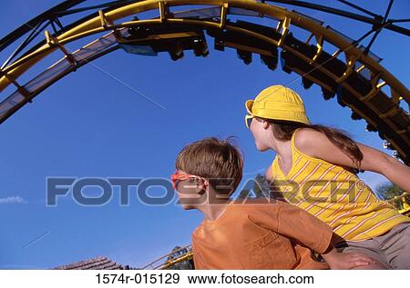 Low angle view of a brother and sister in an amusement park View Large Photo Image Stock Photo - Low angle view of a brother and sister in an amusement park. Fotosearch
