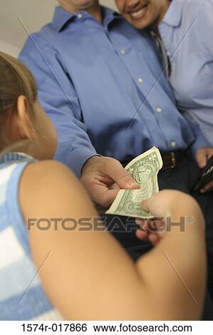Stock Photograph - Low angle view of a daughter taking money from her parents. Fotosearch