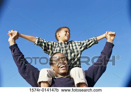 Low angle view of a father carrying his son on his shoulders View Large Photo Image Stock Image - Low angle view of a father carrying his son on his shoulders. Fotosearch