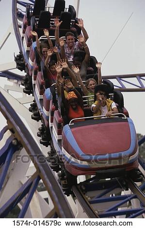 Stock Image - Low angle view of a group of people on a rollercoaster. Fotosearch