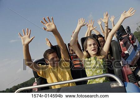 Stock Image - Low angle view of a group of people on a rollercoaster. Fotosearch