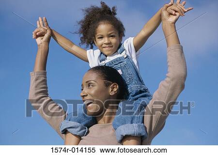 Low angle view of a mother carrying her daughter on her shoulders View Large Photo Image Stock Photography - Low angle view of a mother carrying her daughter on her shoulders. Fotosearch