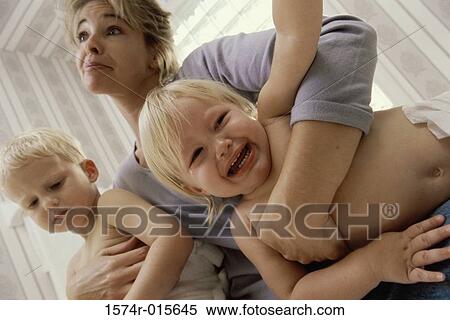 Stock Photography - Low angle view of a mother holding her son and daughter. Fotosearch