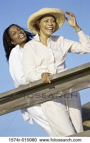Low angle view of a mother standing with her daughter on a deck View Large Photo Image Stock Image - Low angle view of a mother standing with her daughter on a deck. Fotosearch