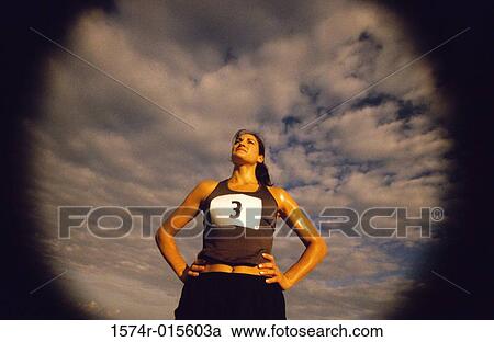 Low angle view of a woman standing with her hands on her hips View Large Photo Image Stock Image - Low angle view of a woman standing with her hands on her hips. Fotosearch