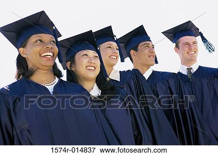 Stock Photo - Low angle view of five teenage graduates standing in a row. Fotosearch