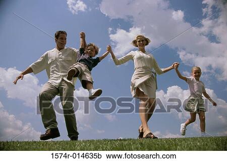 Stock Image - Low angle view of parents swinging their son. Fotosearch