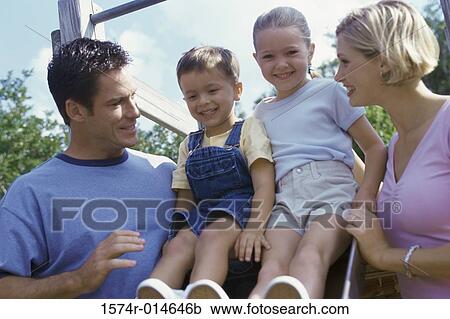 Low angle view of parents with their two children smiling View Large Photo Image Stock Image - Low angle view of parents with their two children smiling. Fotosearch