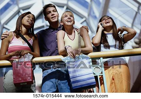 Low angle view of three teenage girls and a teenage boy in a shopping mall View Large Photo Image Picture - Low angle view of three teenage girls and a teenage boy in a shopping mall. Fotosearch