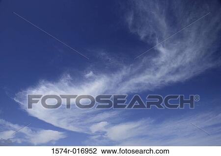 Stock Image - Low angle view of wispy clouds in the sky. Fotosearch
