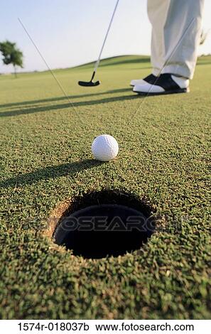 Stock Image - Low section view of a person playing golf in a golf course. Fotosearch
