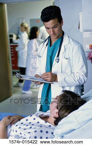 Male doctor taking the report of a patient View Large Photo Image Stock Image - Male doctor taking the report of a patient. Fotosearch