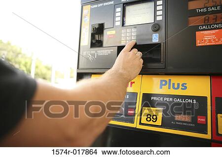 Man's hand pressing the keypad of a fuel pump at a gas station View Large Photo Image Picture - Man's hand pressing the keypad of a fuel pump at a gas station. Fotosearch
