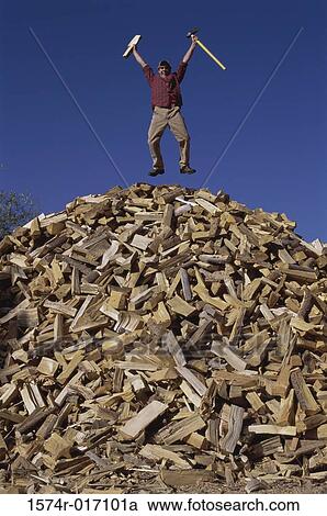 Mid adult man jumping on a heap of firewood View Large Photo Image Stock Image - Mid adult man jumping on a heap of firewood. Fotosearch