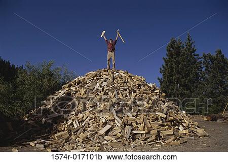 Mid adult man standing on a heap of firewood View Large Photo Image Stock Image - Mid adult man standing on a heap of firewood. Fotosearch