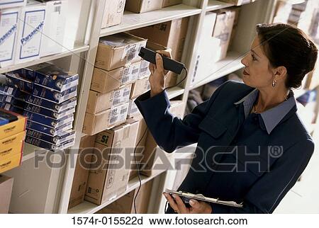 Mid adult woman checking the bar code on products in a warehouse View Large Photo Image Stock Image - Mid adult woman checking the bar code on products in a warehouse. Fotosearch