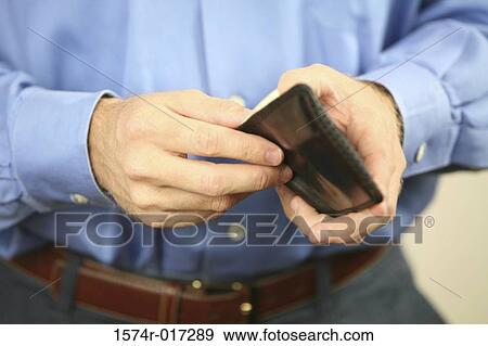 Mid section view of a mid adult man holding a wallet View Large Photo Image Stock Photo - Mid section view of a mid adult man holding a wallet. Fotosearch