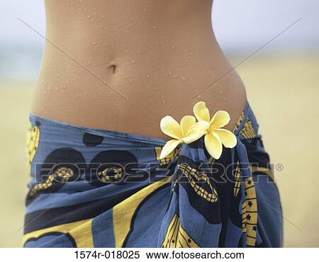 Stock Photography - Mid section view of a woman standing on the beach. Fotosearch