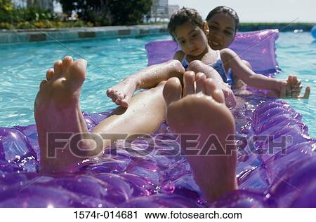 Mother and daughter on a pool raft in a swimming pool View Large Photo Image Stock Image - Mother and daughter on a pool raft in a swimming pool. Fotosearch