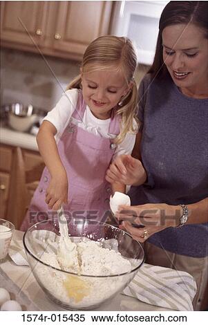 Stock Photography - Mother and daughter preparing food in the kitchen. Fotosearch