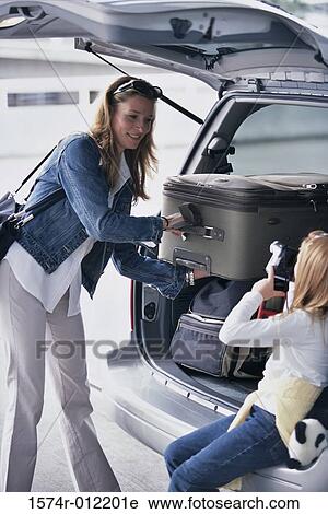 Mother and her daughter loading luggage into the back of a car View Large Photo Image Stock Image - Mother and her daughter loading luggage into the back of a car. Fotosearch