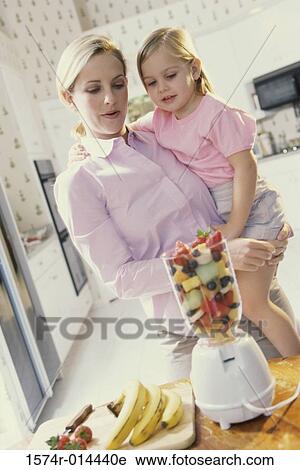 Mother carrying her daughter in front of a blender View Large Photo Image Stock Image - Mother carrying her daughter in front of a blender. Fotosearch