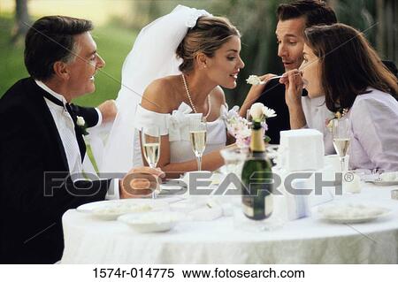 Stock Photography - Mother feeding cake to her daughter. Fotosearch