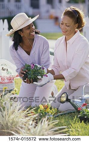 Mother gardening with her daughter View Large Photo Image Stock Image - Mother gardening with her daughter. Fotosearch