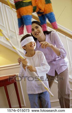 Mother helping her daughter hit a pinata View Large Photo Image Stock Image - Mother helping her daughter hit a pinata. Fotosearch