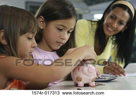 Mother looking at her two daughters inserting coins into a piggy bank View Large Photo Image Stock Image - Mother looking at her two daughters inserting coins into a piggy bank. Fotosearch